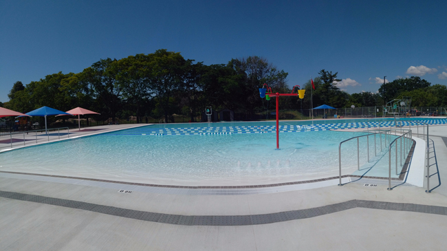 Outdoor lap/leisure pool with dumping buckets and zero depth beach entry at Nelson Pool